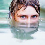 Woman peeking up from under water